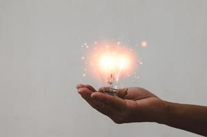 Hand, die Glühbirnen-Ideen hält, großartige Inspiration und Innovation foto