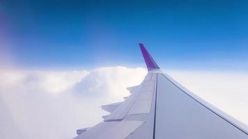 über den Wolken fliegen. Blick vom Passagierfenster des Flugzeugs mit Wolken und Skyline-Horizont. foto