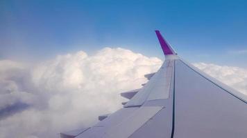 über den Wolken fliegen. Blick vom Passagierfenster des Flugzeugs mit Wolken und Skyline-Horizont. foto