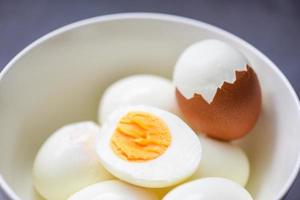 eier frühstück, frisch geschälte eier menü essen gekochte eier in einer schüssel und eierschale, halbiertes eigelb zum kochen einer gesunden ernährung foto