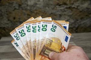 Mannhand, die 50-Euro-Banknoten hält foto
