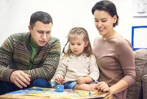 Porträt von glücklich Familie mit wenig Tochter spielen Tabelle Spiel foto