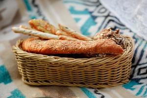 Weidenkorb mit Brot. Brot, Brötchen und Grissini im Korb. frische Backwaren auf Picknick. selektiver Fokus foto