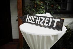 Hochzeitsdeko. Holztafel mit Aufschrift zur deutschen Hochzeit. Hochzeitsdekorationen foto