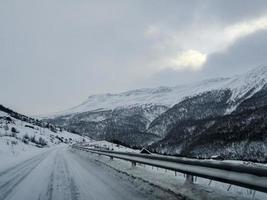 fahren durch verschneite straße und winterlandschaft in norwegen. foto