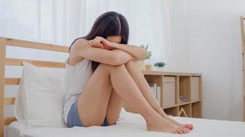 asiatische frau depression traurig auf dem bett im schlafzimmer liegend, schöne japanische frau müde verärgert schlechte laune zu hause. Lifestyle-Frauen mit Entspannungszeit zu Hause Konzept. foto