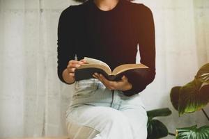 Frauen, die das alte schwere Buch auf weißem Hintergrund lesen. foto