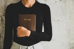 Frauen, die das alte schwere Buch auf weißem Hintergrund lesen. foto