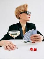 Reife stilvolle Frau im schwarzen Smoking und Sonnenbrille im Casino. glücksspiel, mode, pokerface, hobbykonzept. foto