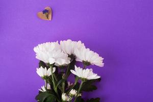 Blumen Zusammensetzung. Muster aus weißen Blumen und einer Blume auf dem Papierherz auf sehr peri Hintergrund foto