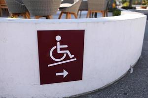 Rollstuhlrampensymbol für Behinderte auf dem Pier in der Nähe des Cafés