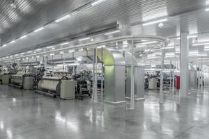 Maschinen und Anlagen in der Weberei. Innenraum der industriellen Textilfabrik foto