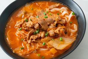 koreanische Udon-Ramen-Nudeln mit Schweinefleisch in Kimchi-Suppe foto