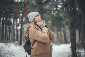 Eine junge Frau mit blonden Haaren geht im Wald spazieren. foto