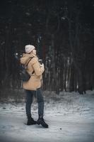 Ein junges Mädchen in Winterkleidung und Spaziergänge im Wald. foto