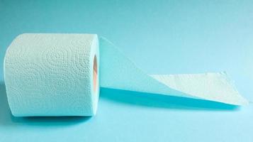 Blaue Rolle modernes Toilettenpapier auf blauem Hintergrund. ein Papierprodukt auf einer Papphülle für Hygienezwecke aus Zellulose mit Ausschnitten zum einfachen Aufreißen. geprägte Zeichnung foto