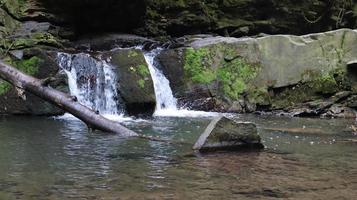 Wasserfälle in einer kleinen Schlucht mit Steinwänden. schöne Kaskade in den Bergen. Fluss in den Karpaten im Bergherbstwald. malerische Aussicht, die Bewegung des Wassers. foto