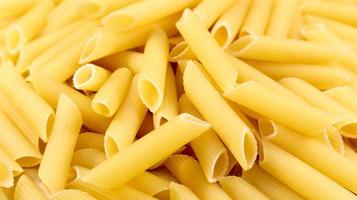 Penne Rigate Raw Pasta ist eine kurze Pasta mit schrägen Schnitten und einer gerippten Oberfläche. traditionelle italienische Pasta. Pasta-Hintergrund. Draufsicht der italienischen Lebensmittelzutat. foto