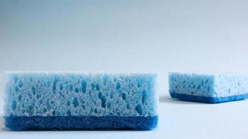 zwei blaue Schwämme zum Waschen und Entfernen von Schmutz, die von Hausfrauen im Alltag verwendet werden. sie bestehen aus porösem Material wie Schaumstoff. Waschmittelrückhaltung, wodurch Sie es wirtschaftlich ausgeben können foto