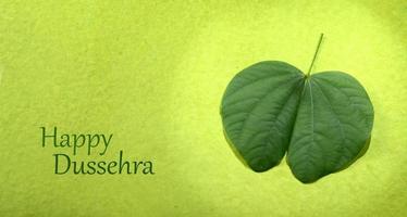 indisches Festival Dussehra, mit goldenem Blatt und Blumen auf grünem Hintergrund. Grußkarte. foto