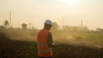 Männlicher Ingenieur, der Drohnen kontrolliert, die Düngemittel und Pestizide über Ackerland sprühen, High-Tech-Innovationen und intelligente Landwirtschaft foto