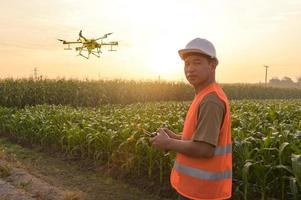 Männlicher Ingenieur, der Drohnen kontrolliert, die Düngemittel und Pestizide über Ackerland sprühen, High-Tech-Innovationen und intelligente Landwirtschaft foto