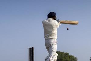 ein Cricketspieler, der Cricket auf dem Spielfeld in weißem Kleid für Testspiele spielt. Sportler, der einen Schuss auf den Cricketball schlägt. foto