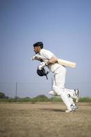 junger indischer Cricketspieler, der das Cricketfeld betritt. indisches cricket- und sportkonzept. foto