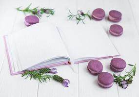 Französische Makronen, sauberes Notizbuch und Lavendelblüten foto