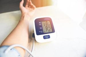 blutdruckmessgerät für männer digital auf holztisch, medizinisches elektronisches tonometer überprüfen blutdruck und herzfrequenz gesundheit und medizinisches konzept. foto