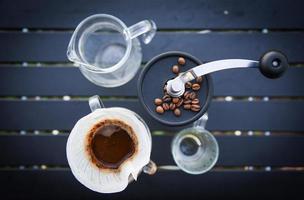 Tropfkaffee-Barista, der Wasser auf gefiltertes Brühen gießt, tropft Kaffee von der Hand im Glas im Freien. foto