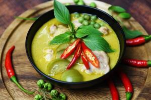 thailändisches essen grünes curry auf suppenschüssel mit zutat kräutergemüse auf holzplattenhintergrund - grünes curry hähnchen küche asiatisches essen auf dem tisch foto