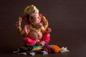 Hindu-Gott Ganesha. Ganesha-Idol auf dunklem Holzhintergrund. foto