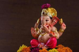 Hindu-Gott Ganesha. Ganesha-Idol auf dunklem Holzhintergrund. foto