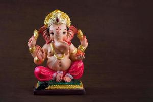 Hindu-Gott Ganesha. Ganesha-Idol auf dunklem Holzhintergrund. foto