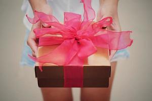 frau hält rote geschenkbox für das geben in den ferien. ferien, geschenk, geschenkkonzept. neujahrstag, weihnachtstag, chinesischer neujahrstag, geburtstag. foto