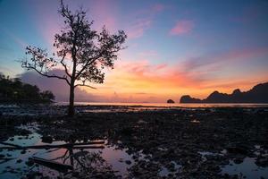 schöner sonnenaufgang dämmerungshimmel am strand meer mit berglandschaft foto