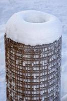 Metall unter dem Schnee. Rolle aus Drahtgeflecht. Lagerung von Metallkonstruktionen im Winter. foto