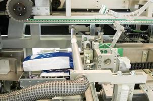 Fabrik und Ausrüstung für die Herstellung von Damenbinden. Verpackungsanlage für Damenbinden auf einem Förderband foto