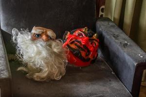 Masken von Sankt Nikolaus und Teufel auf einem Sessel in einem Haus foto