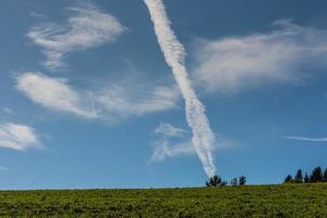 Weiße Kondensstreifen eines Flugzeugs sehen aus wie ein Meteoriteneinschlag foto