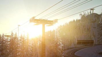 leerer Skilift. Sessellift-Silhouette auf einem hohen Berg über dem Wald bei Sonnenuntergang foto