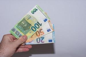 drei Euro-Banknoten in einer Hand nach oben mit Grau gehalten foto