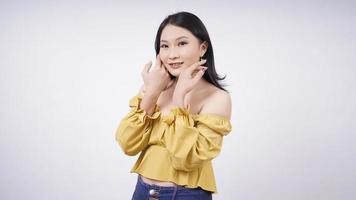 schöne asiatische Frau lächelnd zeigt ihr Make-up isoliert auf weißem Hintergrundschöne asiatische Frau lächelnd zeigt ihr Make-up isoliert auf weißem Hintergrund foto