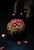 Schoko-Dragees in knusprig farbiger Glasur. Dragee mit Mandeln in einer Keramikvase. bunte Bonbons auf dem Tisch foto