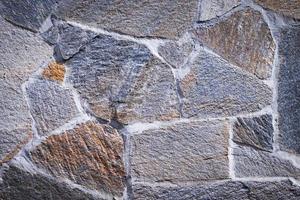 Steinstruktur. Dunkelgraue und Brownstone-Wand aus Naturstein. Nahansicht. Schutt Wand Hintergrund. foto
