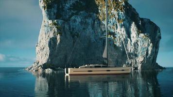 Yacht im Meer mit grüner Felseninsel foto