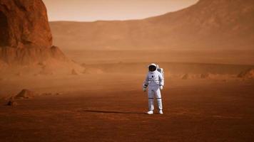 astronaut auf der marsoberfläche. Roter Planet, der mit Gas und Gestein bedeckt ist foto