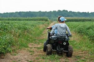 Zwei Brüder, die ein Vierrad-ATV-Quad fahren. glückliche Kindermomente. foto