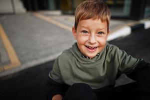 Nahaufnahme Porträt eines lächelnden sitzenden Jungen im Sportanzug. foto